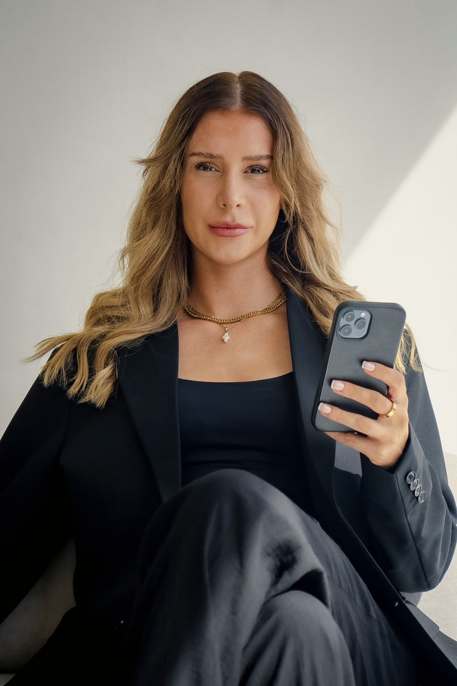 Liv Ball holding a phone, looking at the camera
